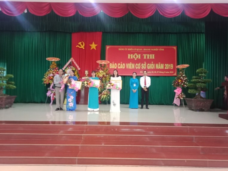 Đồng chí Dương Quốc Hoàng đại diện Đảng bộ Trường Chính trị tặng hoa chúc mừng đồng chí Nguyễn Thị Nga.